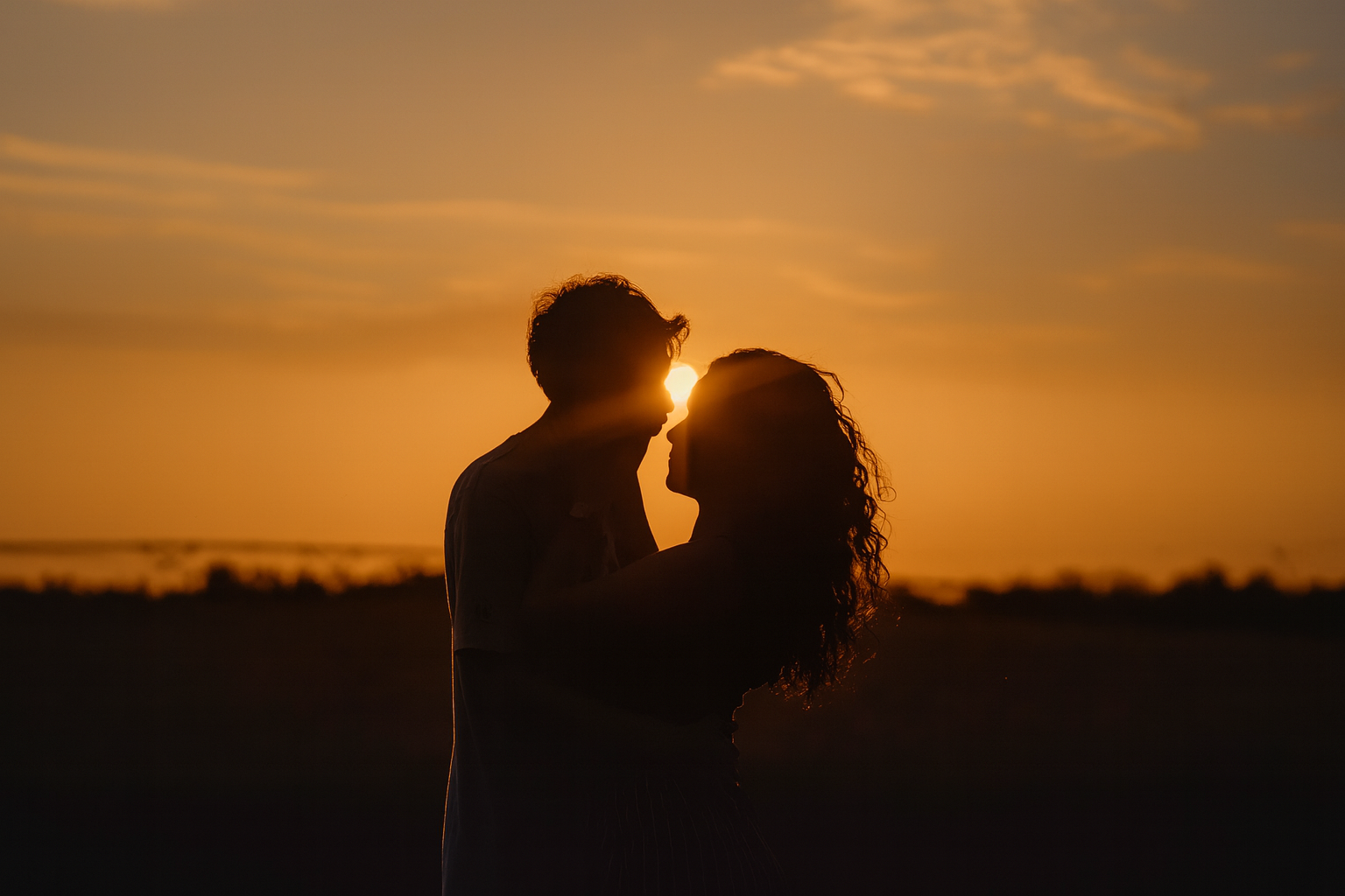 2 Liebende Menschen in einer Umarmung bei Sonnenuntergang
